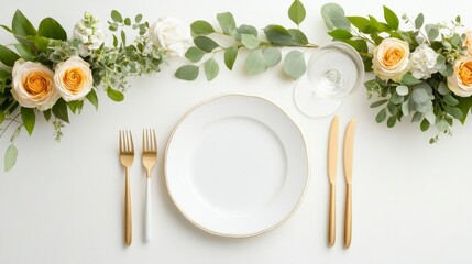 A beautifully set dining table featuring a white plate, gold utensils, and elegant floral arrangements, perfect for a special occasion.