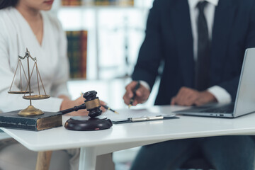 Lawyer and Client Discussing Case: A lawyer and client intently review legal documents, with a...