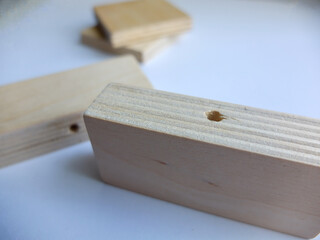 Wooden furniture parts and a bag of fittings for assembling furniture in a room against the wall.