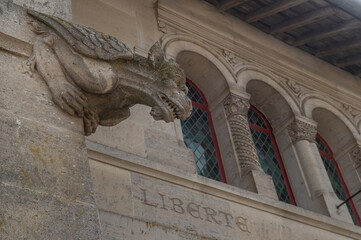 une chimère sculptée dans la pierre au dessus du mot Liberté