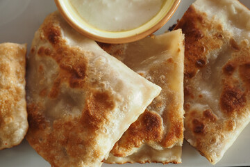 Enjoy delicious, crispy flatbreads served with a delightful dipping sauce for your enjoyment