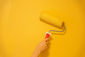 Roller Brush Painting, Worker painting on surface wall Painting apartment, renovating with yellow...