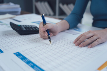 Focused on Success: A close-up view of a woman's hand meticulously filling out paperwork, a pen...