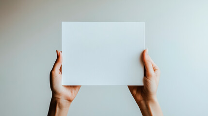 A pair of african hands holding an empty white paper, with the background being pure and clean.