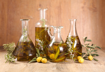assorted of differents bottles with olive oil, tree branch and rosemary