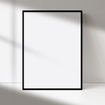 Mockup of a blank poster canvas painting artwork with a black frame vertical portrait gray wall and floor on background.