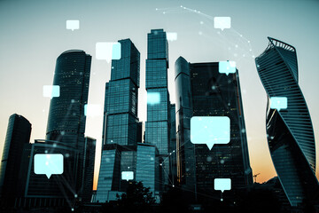 Communication network concept with speech bubbles over city skyscrapers at sunset.