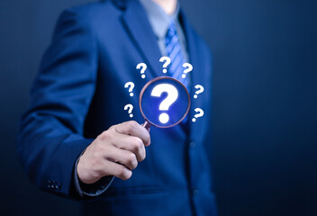 Businessman showing question mark on laptop. Concept of asking, answering, business FAQ, thinking and wondering, brainstorming and problem solving.