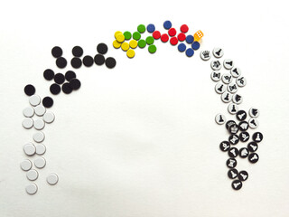 Colorful game pieces arranged in rainbow formation on white background