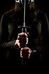 A woman in a mask and Japanese traditional headdress sugegasa poses with a samurai sword. Japanese...