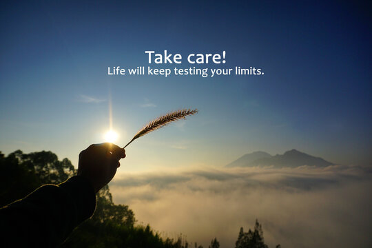 Life inspirational motivational quote - Take care. Life will keep testing your limits. With hand of person holding grass flower against the sun and sky over mountain with fog. Life challenge concept.
