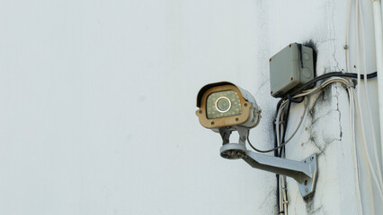 A close-up view of a surveillance camera mounted on a wall, highlighting modern security technology in urban environments.