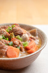 豆腐と人参と大根と蒟蒻の入ったもつ煮込み