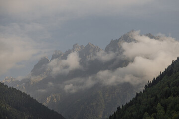 Majestic and aweinspiring mountain peaks are beautifully shrouded in fluffy, white clouds