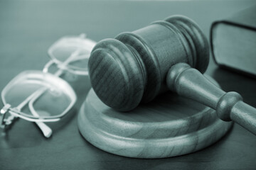 Close up of gavel, legal book and eyeglasses on table	