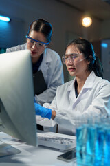 Two Asian female scientists talk Discuss concepts and use PC in evaluating research data in Medical...