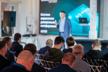 Business professional delivers engaging presentation to attentive audience in modern setting, focusing on key concepts and innovative solutions.