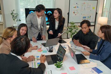 Financial analyst analyzes business finance reports on laptop and graph documents during corporate meeting discussions showing successful teamwork, business meeting ideas, marketing.