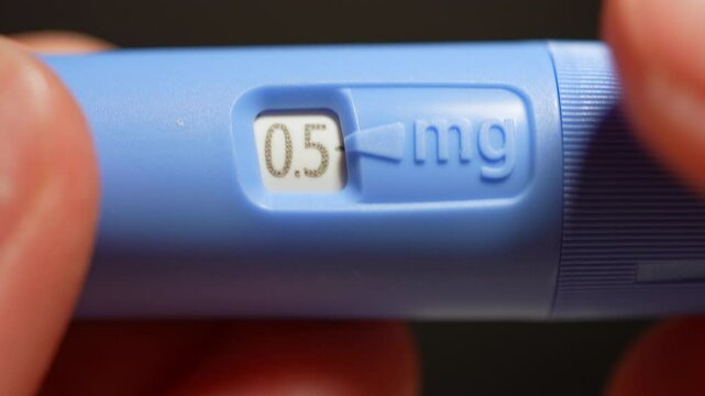 Diabetes Injector pen dosage of the medication display, macro close up. Drug for diabetes prevention and weight loss. View at injector pen in hands.