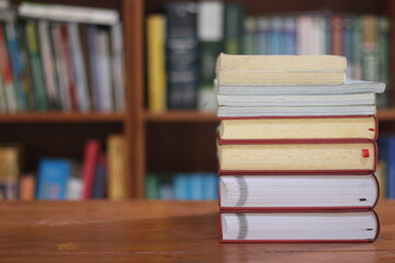 stack of books on wooden table against blurred background. space for text, education, school