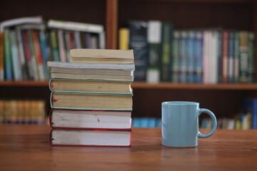 stack of books on wooden table against blurred background. space for text, education, school