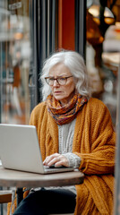 Obraz premium An elderly woman using a laptop computer AI generative.