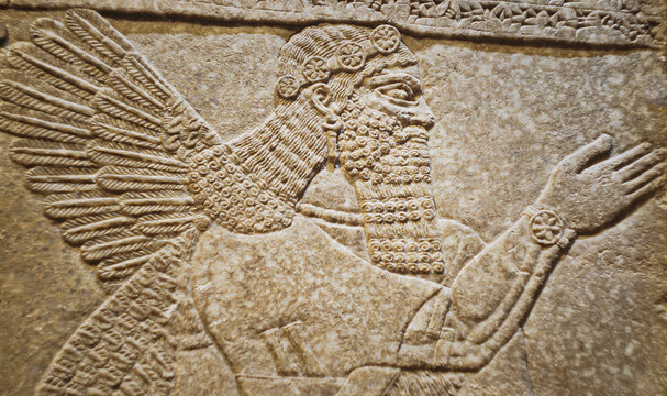 Close-up view on Winged Figure. Architectural Fragment Of Panel From Northwest Palace Of Ashurnasirpal Ii By Neo Assyrian Period. Depicted Is Winged Human Divine Spirit, Protective Spirit. High Priest