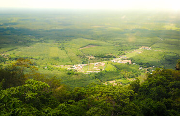Fototapeta premium Land, landscape of green field in aerial view. Include agriculture farm, house building, village. That real estate or property. Plot of land to housing subdivision, development, sale or investment.