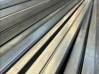 Close-up of lightweight steel hollow bars stacked together, used as durable construction material in building and industrial projects.