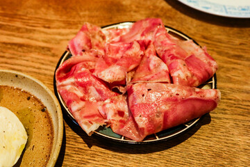 close up of salami ham cut in slices on a plate as appetizer cold cut