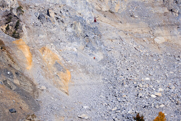Rockfall at mountain village of Brienz Brinzauls with helicopter and workers hanging on rope in the Swiss Alps on a sunny autumn day. Photo taken November 15th, 2024, Brienz Brinzauls, Switzerland.
