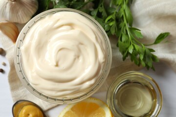 Bowl with mayonnaise and ingredients for cooking on gray background