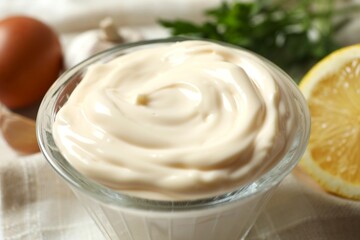 Bowl with mayonnaise and ingredients for cooking on gray background