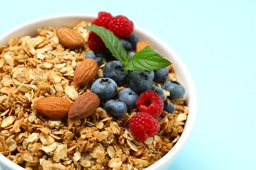 Delicious granola with berries on a color background