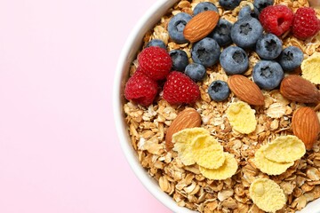 Delicious granola with berries on a color background