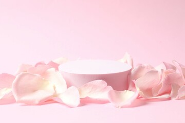 Pink rose petals with podium on a color background