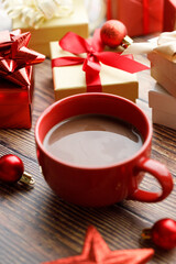 Cup of hot cocoa among vivid gift boxes