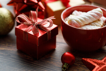 Cup of hot cocoa among vivid gift boxes