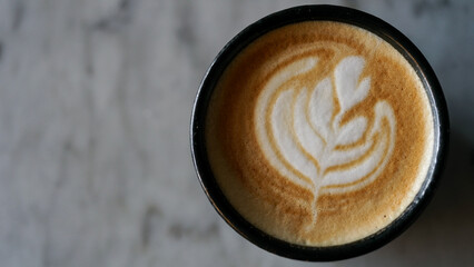 Top view of a cup of cappuccino on a marble table with copy space