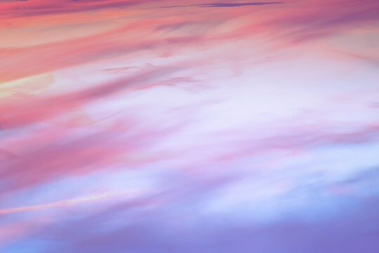 Twilight sky with effect of light in pastel pink, coral, orange, blue tones. Colorful sunset of soft clouds. Background