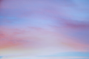 Obraz premium Sky with soft and fluffy pastel orange pink and blue colored clouds. Sunset background. Nature. sunrise.