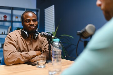Podcast presenter having live discussion with man, streaming it for audience on internet...