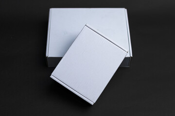 Two boxes sitting on top of each other one slightly smaller than the other The smaller one is on...