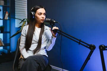 woman records podcast, speaking into microphone