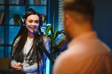 Side view of successful woman hosting podcast interviewing man while recording with professional...