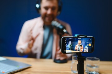 Man smiling while recording podcast in studio