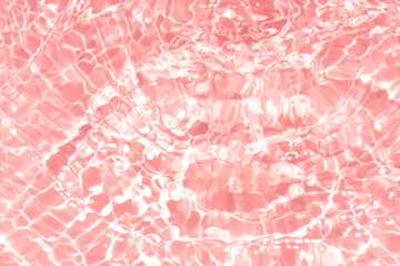 Pink water bubbles on the surface ripples. Defocus blurred transparent pink colored clear calm water surface texture with splash and bubbles. Water waves with shining pattern texture background