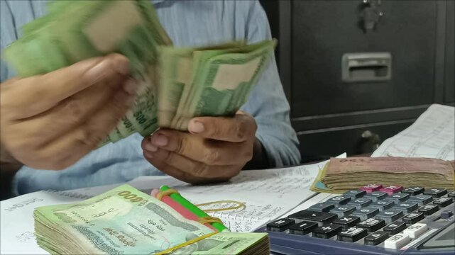 A cashier counts money at a microfinance institution in Bangladesh. 