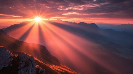 Majestic Sunrise Over Mountain Peaks with Rays of Light Breaking Through Clouds