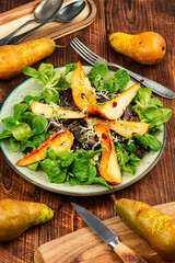 Salad with liver, caramelized pear in a plate.